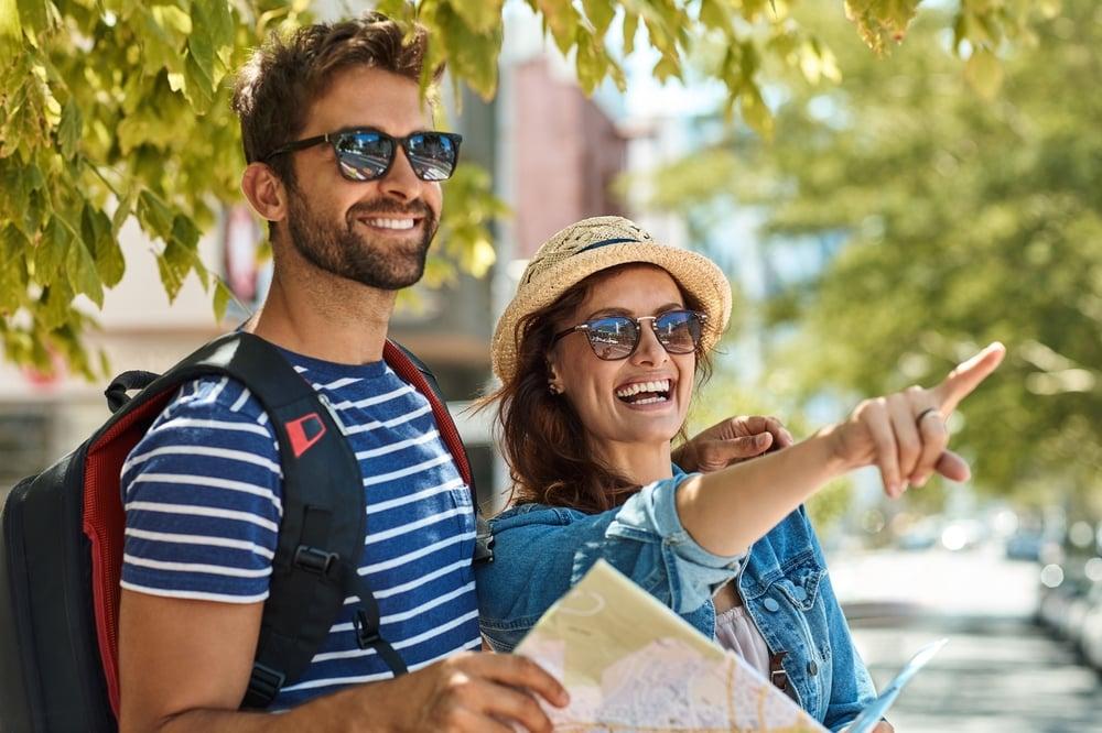 Happy couple of tourists planning travel